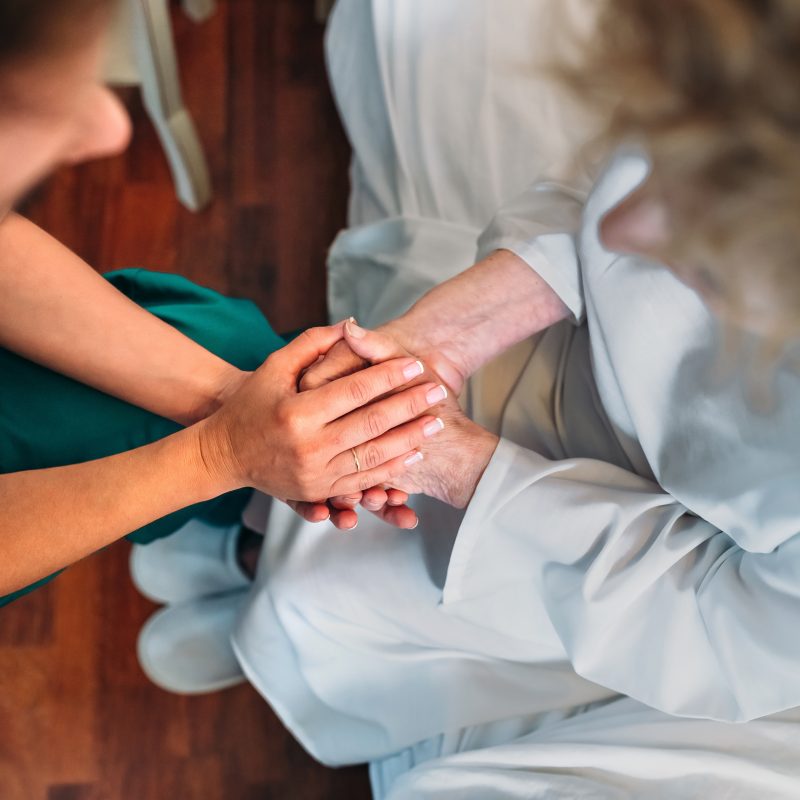 female doctor giving encouragement elderly patient by holding her hands - Cn2r